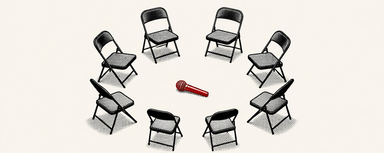 A ring of folding chairs seen from above with a microphone in the middle