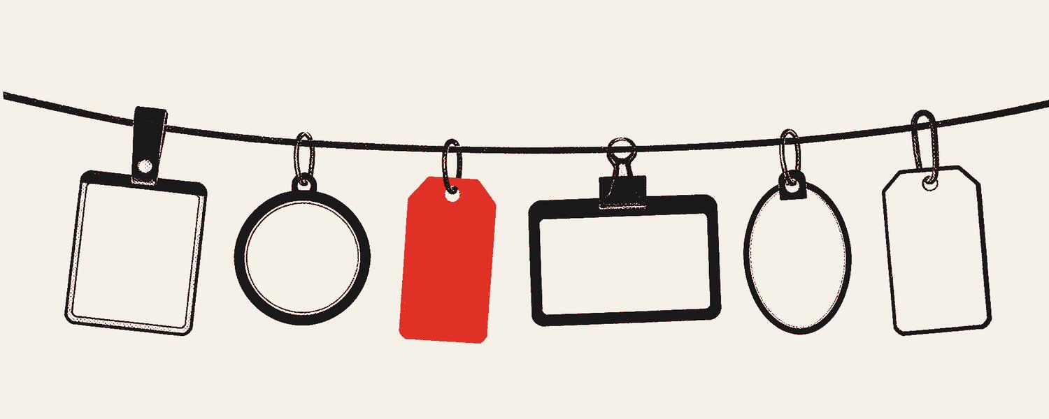 A row of blank name tags hanging on a string, one of them red